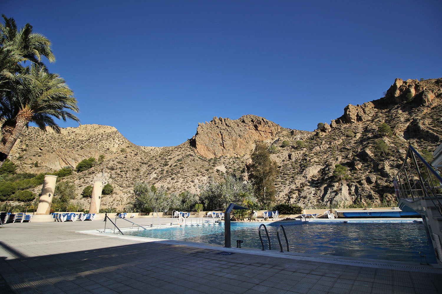 view of outdoor swimming pool with hills in the background
