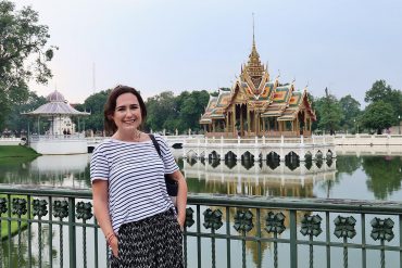 Thai palace on a lake with woman in foreground