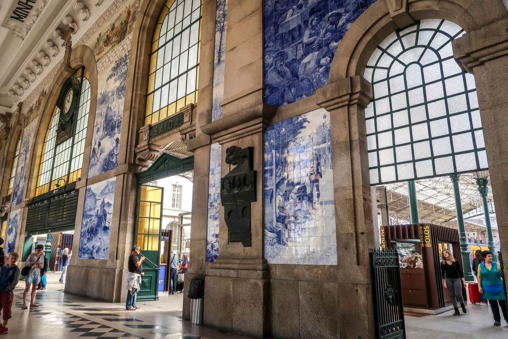 inside the train station with large arched windows surrounded by blue and white tiles