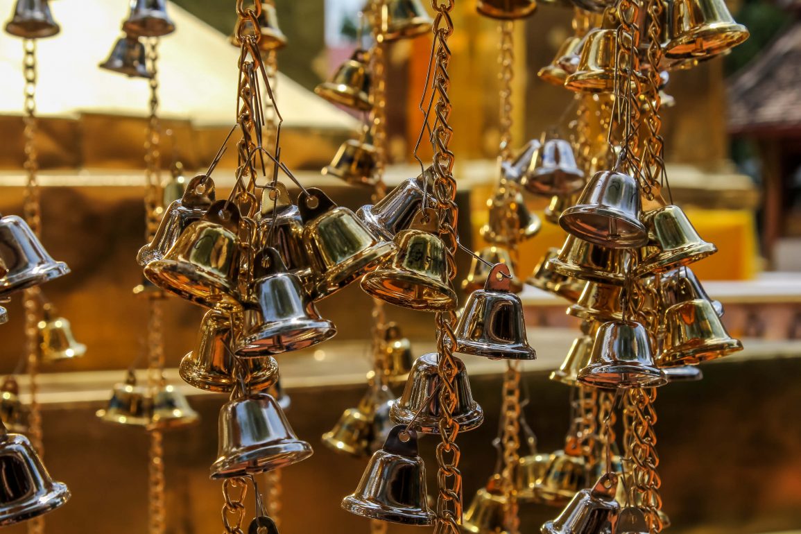 Close up of strings of small gold bells