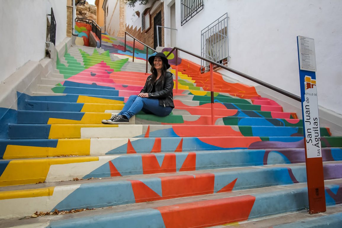 woman sits on colourful steps