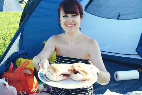 woman holds up a plate of bacon baps to the camera