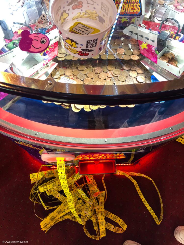2p amusement machine with large number of yellow winning tickets coming out the front.