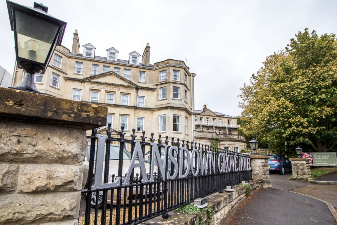 Exterior photo of the hotel with iron fence and sign saying lansdown grove hotel